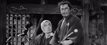 Movie still from “Yojimbo” (1961), directed by Akira Kurosawa – An older woman and a younger man in traditional japanese garb; Medium shot, Low angle