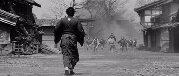 Movie still from “Yojimbo” (1961), directed by Akira Kurosawa – A group of people are running in the dirt; Wide shot, Low angle