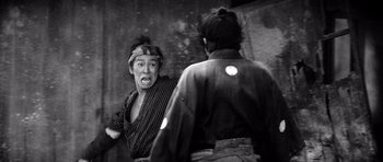 Movie still from “Yojimbo” (1961), directed by Akira Kurosawa – Two men are fighting in front of a mirror; Medium shot, Low angle