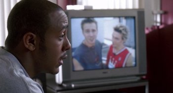 Movie still from “You Got Served” (2004), directed by Chris Stokes – A man looking at a television screen with two men on it; Close Up shot, Over the shoulder angle