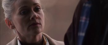 Movie still from “You're Next” (2011), directed by Adam Wingard – An older woman looking down at the ground; Close Up shot, Over the shoulder angle