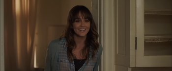 Movie still from “You're Next” (2011), directed by Adam Wingard – A woman with long brown hair wearing a plaid shirt; Close Up shot, Over the shoulder angle