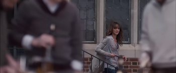 Movie still from “You're Next” (2011), directed by Adam Wingard – A woman walking down the stairs of a building; Medium shot, Over the shoulder angle