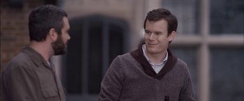 Movie still from “You're Next” (2011), directed by Adam Wingard – A man in a sweater smiling for the camera; Close Up shot, Over the shoulder angle