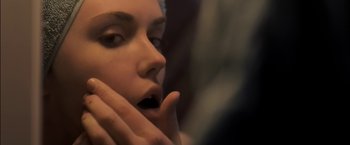 Movie still from “You're Next” (2011), directed by Adam Wingard – A woman's face with her hands near her mouth; Extreme Close Up shot, Over the shoulder angle