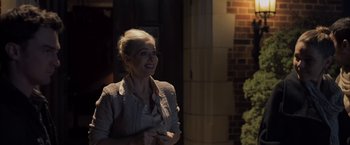 Movie still from “You're Next” (2011), directed by Adam Wingard – A woman standing in front of a brick building; Medium shot, Over the shoulder angle