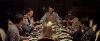Movie still from “You're Next” (2011), directed by Adam Wingard – A group of people sitting around a dinner table; Medium shot, Over the shoulder angle