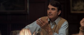 Movie still from “You're Next” (2011), directed by Adam Wingard – A man sitting in front of a glass of wine; Close Up shot, Over the shoulder angle