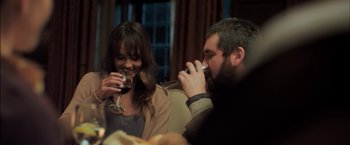 Movie still from “You're Next” (2011), directed by Adam Wingard – A man and a woman drinking wine at a dinner table; Medium shot, Over the shoulder angle