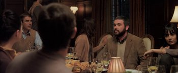 Movie still from “You're Next” (2011), directed by Adam Wingard – A man and a woman sitting at a dinner table; Medium shot, Over the shoulder angle