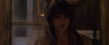 Movie still from “You're Next” (2011), directed by Adam Wingard – A woman with long brown hair is looking at the camera; Close Up shot, Over the shoulder angle