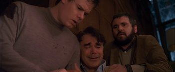 Movie still from “You're Next” (2011), directed by Adam Wingard – A man crying next to two other men in a room; Close Up shot, Low angle