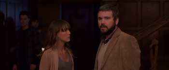 Movie still from “You're Next” (2011), directed by Adam Wingard – A man and a woman standing next to each other; Medium shot, Over the shoulder angle