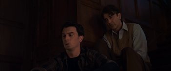 Movie still from “You're Next” (2011), directed by Adam Wingard – Two men sitting next to each other in a dark room; Medium shot, High angle