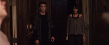 Movie still from “You're Next” (2011), directed by Adam Wingard – A man and a woman standing next to each other in a dark room; Medium shot, High angle