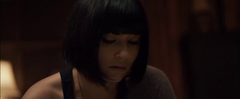 Movie still from “You're Next” (2011), directed by Adam Wingard – A woman with black hair is looking down at her face; Close Up shot, High angle