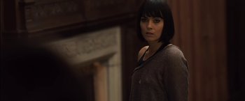 Movie still from “You're Next” (2011), directed by Adam Wingard – A woman standing in front of a fireplace; Close Up shot, Over the shoulder angle