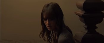 Movie still from “You're Next” (2011), directed by Adam Wingard – A woman with long brown hair and bangs looking to her left; Close Up shot, High angle