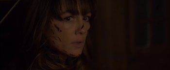 Movie still from “You're Next” (2011), directed by Adam Wingard – A person with blood on their face; Close Up shot, Over the shoulder angle