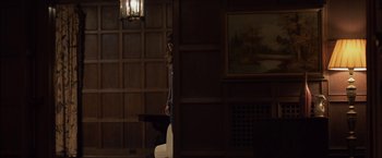 Movie still from “You're Next” (2011), directed by Adam Wingard – A woman standing in front of a wooden wall; Wide shot, Over the shoulder angle