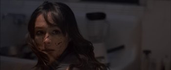 Movie still from “You're Next” (2011), directed by Adam Wingard – A young woman with brown spots on her face; Close Up shot, Over the shoulder angle