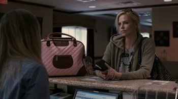 Movie still from “Young Adult” (2011), directed by Jason Reitman – A woman sitting in front of a pink purse; Medium shot, Over the shoulder angle