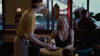 Movie still from “Young Adult” (2011), directed by Jason Reitman – A woman sitting at a table in front of a man; Medium shot, Over the shoulder angle
