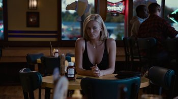 Movie still from “Young Adult” (2011), directed by Jason Reitman – A woman sitting at a table in a restaurant; Medium shot, Over the shoulder angle