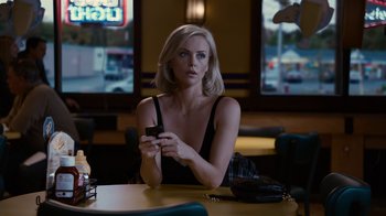 Movie still from “Young Adult” (2011), directed by Jason Reitman – A woman sitting at a table holding a cell phone; Medium shot, Over the shoulder angle