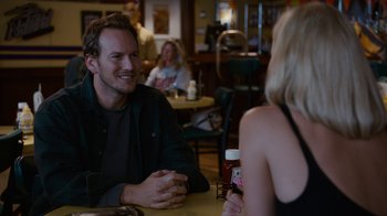 Movie still from “Young Adult” (2011), directed by Jason Reitman – A man and a woman are sitting at a table; Medium shot, Over the shoulder angle