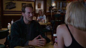 Movie still from “Young Adult” (2011), directed by Jason Reitman – A man and a woman are sitting at a table talking; Medium shot, Over the shoulder angle