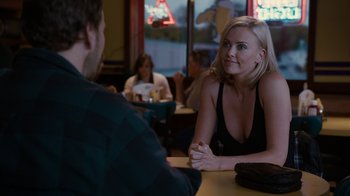 Movie still from “Young Adult” (2011), directed by Jason Reitman – A woman sitting at a table in front of a man; Medium shot, Over the shoulder angle