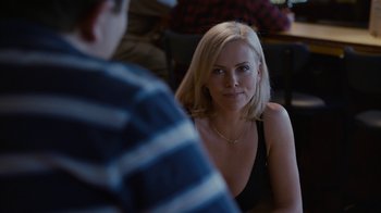 Movie still from “Young Adult” (2011), directed by Jason Reitman – A woman sitting in front of a man in front of a table; Close Up shot, Over the shoulder angle