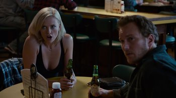 Movie still from “Young Adult” (2011), directed by Jason Reitman – A woman sitting at a table with a man drinking a beer; Close Up shot, Over the shoulder angle