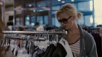 Movie still from “Young Adult” (2011), directed by Jason Reitman – A woman looking at clothes on a clothing rack; Medium shot, Over the shoulder angle