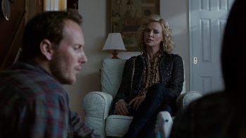 Movie still from “Young Adult” (2011), directed by Jason Reitman – A woman sitting in a chair with a man in front of her; Medium shot, Over the shoulder angle