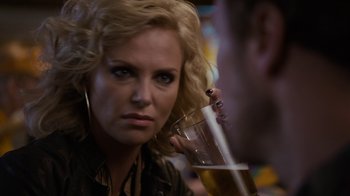 Movie still from “Young Adult” (2011), directed by Jason Reitman – A woman holding a glass of beer in front of a man; Close Up shot, Over the shoulder angle