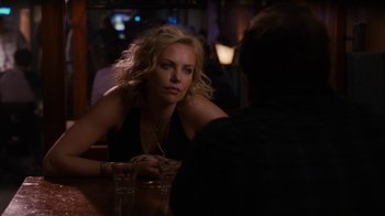 Movie still from “Young Adult” (2011), directed by Jason Reitman – A woman sitting at a table with a glass of water; Close Up shot, Over the shoulder angle