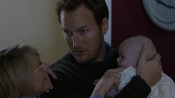 Movie still from “Young Adult” (2011), directed by Jason Reitman – A man holding a baby in his arms; Close Up shot, Over the shoulder angle