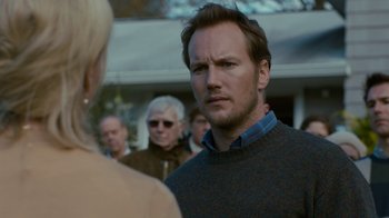 Movie still from “Young Adult” (2011), directed by Jason Reitman – A man in a sweater is standing in front of a group of people; Close Up shot, Over the shoulder angle