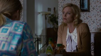 Movie still from “Young Adult” (2011), directed by Jason Reitman – A woman sitting in front of a table with food; Medium shot, Over the shoulder angle