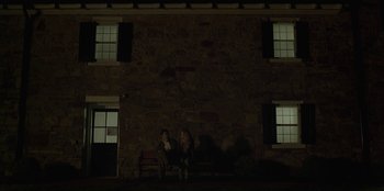 Movie still from “House of Cards” (2013), created by Beau Willimon – Two people sitting on a bench in front of a stone building; Wide shot, Low angle