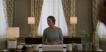 Movie still from “House of Cards” (2013), created by Beau Willimon – A woman sitting in front of a cake on top of a table; Medium shot, Low angle