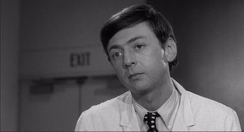 Movie still from “Young Frankenstein” (1974), directed by Mel Brooks – A black and white photo of a man wearing a suit and tie; Close Up shot, Over the shoulder angle