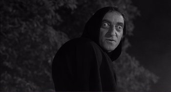 Movie still from “Young Frankenstein” (1974), directed by Mel Brooks – A man in a black robe with a hood on; Close Up shot, Low angle