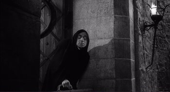 Movie still from “Young Frankenstein” (1974), directed by Mel Brooks – An old man wearing a black robe and glasses; Medium shot, Low angle