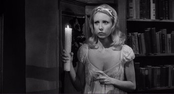 Movie still from “Young Frankenstein” (1974), directed by Mel Brooks – A black and white photo of a woman holding a candle; Medium shot, Over the shoulder angle