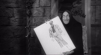 Movie still from “Young Frankenstein” (1974), directed by Mel Brooks – An old woman holding a drawing of a man; Medium shot, Low angle