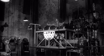 Movie still from “Young Frankenstein” (1974), directed by Mel Brooks – A man standing in front of an airplane in a garage; Wide shot, Low angle