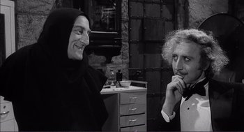 Movie still from “Young Frankenstein” (1974), directed by Mel Brooks – Two people sitting next to each other in a room; Medium shot, Over the shoulder angle